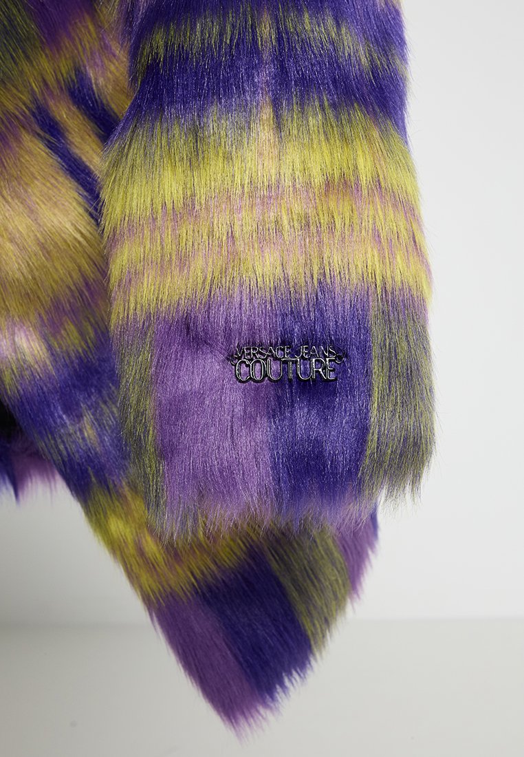 Mehrfarbiges Kunstfellgewebe mit kräftigen lila, gelben und grünen Streifen, mit einem metallischen "Versace Jeans Couture"-Tag.