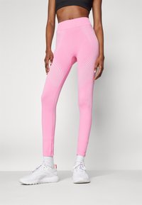 Leggings fucsia a vita alta con dettagli testurizzati, una vestibilità aderente e fantasie decorative di cucitura lungo i lati.