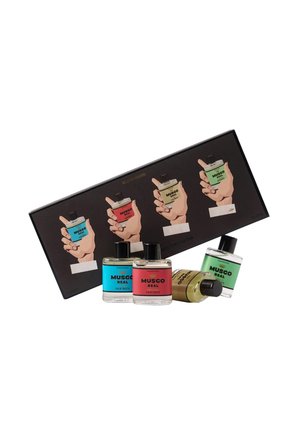 Ensemble de quatre flacons d'eau de toilette Musgo Real en bleu, rouge, jaune et vert, accompagnés d'une boîte noire avec des illustrations de mains tenant chaque parfum.