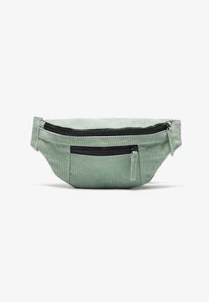 Grøn kordon-velour bumbag med to sorte lynlåse, en tekstureret overflade og en rund form. Har en lomme foran og justerbar rem.