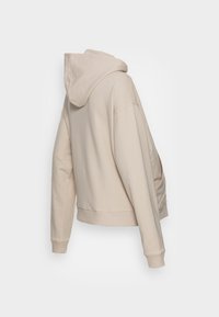 Beige mikina s dlouhým rukávem a žebrovanými manžetami a spodním lemem, zobrazená z zadní části na bílém pozadí.