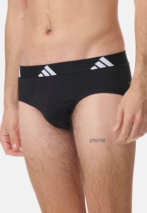 Culottes en coton noir avec une ceinture élastique rayée blanche et une coupe ajustée, mettant en avant une texture lisse et des coutures minimales.