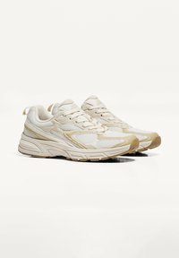 Scarpe da ginnastica beige realizzate in rete e materiali sintetici. Caratterizzano un upper testurizzato, colletto imbottito e suola in gomma con motivi di trazione.