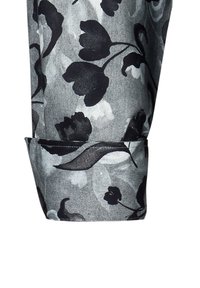 Tessuto stampato floreale con tonalità di grigio e nero. Presenta un risvolto arrotolato con una leggera lucentezza, una consistenza liscia e intricati motivi floreali.