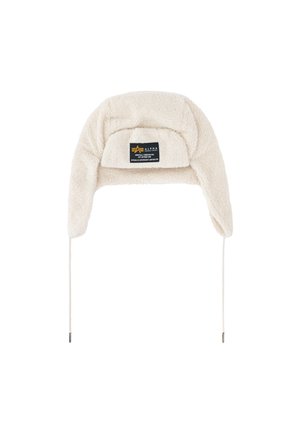 Cream-colored fleece trapper hat with ear flaps and a black rectangular label on the front reading Alpha Industries.