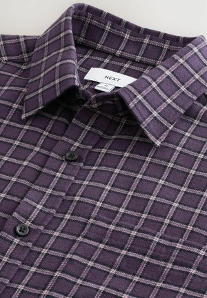 Violets flaneļa krekls ar pārbaudes rakstu gaiši rozā un melnā krāsā, ar punktveida apkakli un melniem pogām. Zīmola etiķete ir redzama.