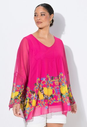 Durchsichtige pinke Tunika mit V-Ausschnitt, die ein buntes Blumen- und Zitronenmuster am Saum aufweist. Lockere Ärmel und leichtes Material.