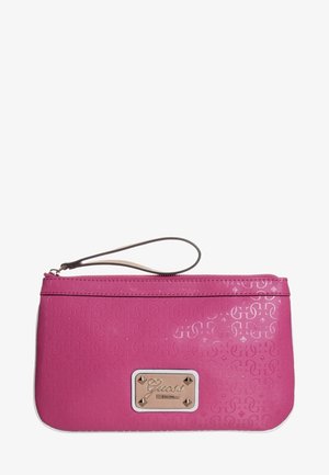 Pochette bracelet rose avec motif embossé, fermeture éclair et plaque de logo rectangulaire dorée indiquant "Guess EST 1981" sur le devant.