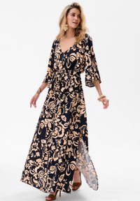 Sukienka maxi w granatowym materiale z beżowym florystycznym wzorem. Posiada dekolt w kształcie litery V, paskiem w talii oraz rękawami 3/4 z bocznym rozcięciem.