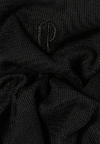 Tela negra acanalada con una textura suave, que presenta un logo en relieve en un tono similar, creando un detalle visual sutil.