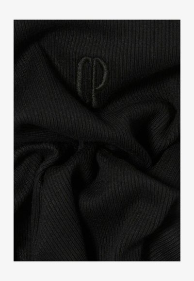 Tela negra acanalada con una textura suave, que presenta un logo en relieve en un tono similar, creando un detalle visual sutil.