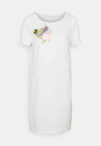 Biała, krótko rękawowa sukienka z okrągłym dekoltem, z wielokolorowym haftem kwiatowym po lewej stronie. Gładki materiał bawełniany.