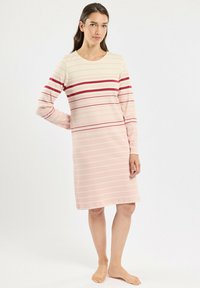 Robe à manches longues de couleur rose clair avec des rayures horizontales de teintes plus foncées. Encolure ronde, coupe confortable, texture lisse, design mi-long.