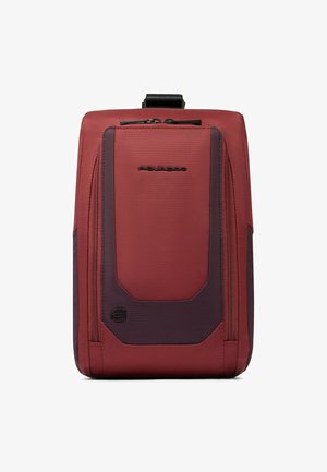 Roter und dunkelvioletter Rucksack mit strukturierter Oberfläche, zentralem Reißverschlussfach, Logodetail und schlankem Design.