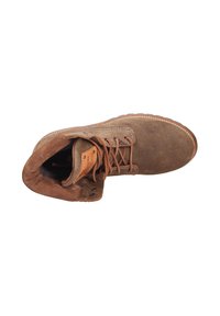 Stivaletto in suede marrone con punta arrotondata, lacci marroni e una toppa in pelle; presenta un morbido rivestimento interno e una suola in gomma texturizzata.