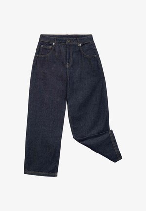 Ciemnoniebieskie dżinsy z denimu z guzikiem i zamkiem błyskawicznym z przodu, pięć kieszeni i jedna nogawka lekko zgięta w kolanie.