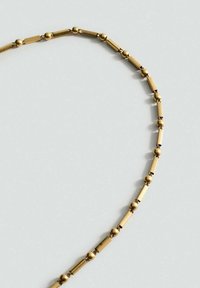 Goldkettchen mit einem Muster aus abwechselnden zylindrischen und sphärischen Gliedern. Glatte Textur mit polierter Oberfläche.