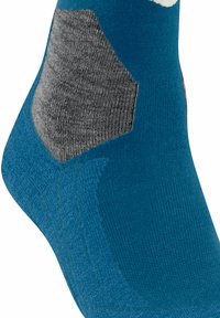 Calzino turchese con un rinforzo esagonale grigio sul tallone. Realizzato in un tessuto morbido e testurizzato, presenta colori a contrasto e dettagli di cucitura lisci.