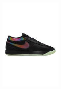 Sneaker nera con tomaia in mesh, dettagli neri strutturati, logo Nike iridescente riflettente e suola color crema.