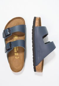 Mørkeblå Birkenstock sandaler med to justerbare stropper, korkfotbed og en sort gummisåle. Logoet er preget på siden.