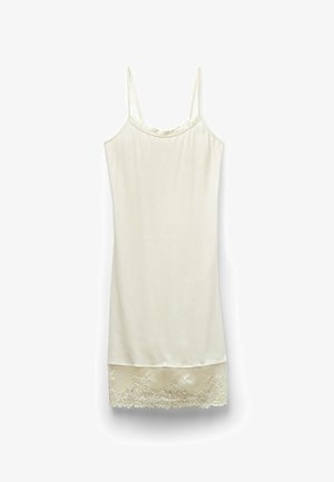 Ljus gräddfärgad sömnkörning med tunna axelband, spetsdetaljer längs midjan och en spetsaccenterad fåll. Mjuk, slät tyg med en figurnära form.