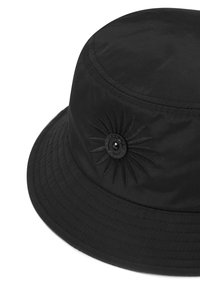 Svart bucket-hatt tillverkad av hållbart tyg, med en broderad solstråle-design och en rund svart knappdetalj på framsidan.