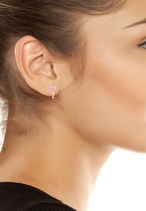 Orecchino a forma di fenicottero rosa con accenti in argento, caratterizzato da dettagli in smalto e un design minimalista. Leggero e fantasioso.