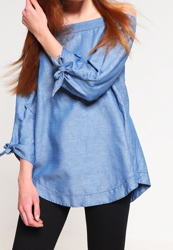 Modrá šambráová off-the-shoulder blůza s dlouhými rukávy, která má na manžetách mašličkové detaily. Volný střih a zakřivený lem.