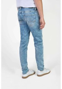 Lichtblauwe denim jeans met een slim fit, voorzien van twee achterzakken en een vervaagde textuur. Draag ze met witte schoenen en een effen t-shirt.