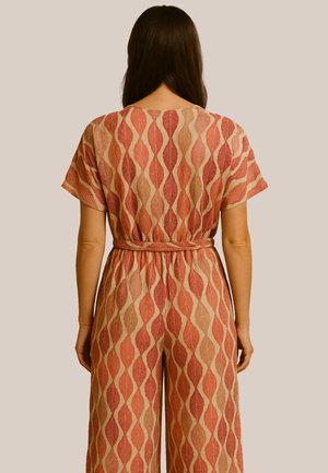 Jumpsuit à motifs rouge et beige avec un design de feuillage, manches courtes et taille nouée. Le tissu texturé rehausse le détail visuel.
