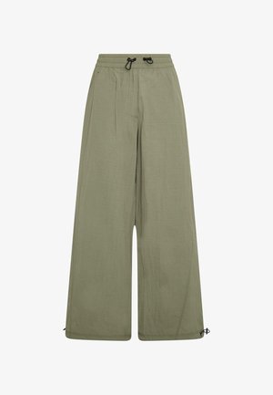 Pantaloni ampi color verde oliva chiaro realizzati in tessuto morbido, con vita elastica e cordino, e lacci regolabili alla caviglia.