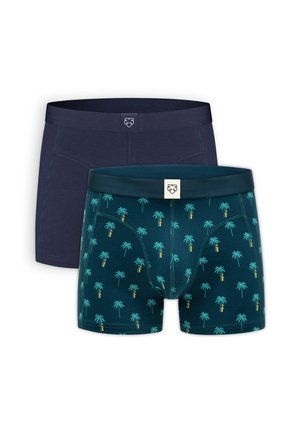 Deux caleçons-boxers pour hommes, l'un uni bleu marine foncé et l'autre vert sarcelle foncé avec un motif de palmiers turquoise et jaune, tous deux avec une étiquette logo au centre de la ceinture.