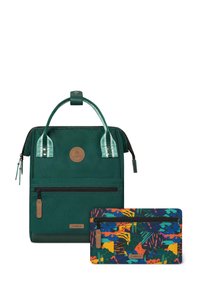 Grüner Rucksack mit strukturiertem Finish, ausgestattet mit einer Vorderreißverschlusstasche und einer mehrfarbigen gemusterten Tasche darunter. Mit einem Logo-Anhänger akzentuiert.