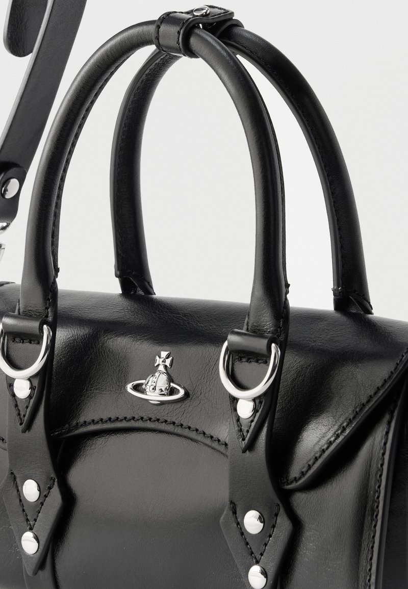 Bolso de cuero negro con asas dobles enrolladas, herrajes en forma de anillo plateado y un logo plateado de orbe en la solapa frontal.