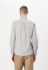 Chemise à manches longues pour homme en motif à carreaux gris clair, avec un col boutonné, une coupe ajustée et des poignets boutonnés, fabriquée en un doux mélange de coton.