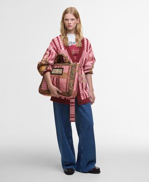 Roze en rode gestreepte oversized trui, blauwe wijde spijkerbroek en een gestreepte tote bag met bruine accenten en een decoratieve patch.