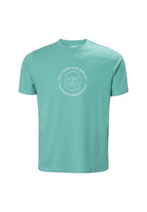 Camiseta de manga corta color verde azulado claro con cuello redondo y logo blanco de Helly Hansen en el centro, junto con un texto circular que dice "Helly Hansen Vivo Desde 1877 Confiado por Profesionales".