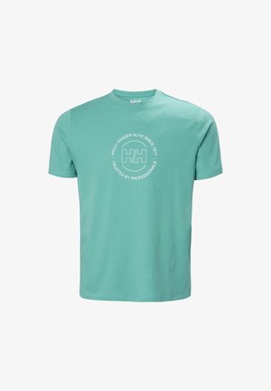 Camiseta de manga corta color verde azulado claro con cuello redondo y logo blanco de Helly Hansen en el centro, junto con un texto circular que dice "Helly Hansen Vivo Desde 1877 Confiado por Profesionales".