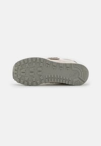 Semelle de sneaker en caoutchouc gris épais et texturé, avec des motifs de semelle multidirectionnels et un design qui ne marque pas.