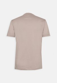 Ljus taupe t-shirt med kort ärm och rund halsringning. Slät textur, enkel design och sydd fåll. Bakvy visas.