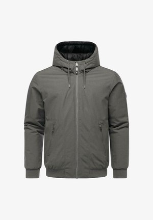 Kapuzenshülle aus grauem Material mit durchgehendem Reißverschluss, zwei seitlichen Taschen und gerippten Bündchen. Glatte Außenseite mit gepolsterter Innenseite für zusätzliche Wärme.