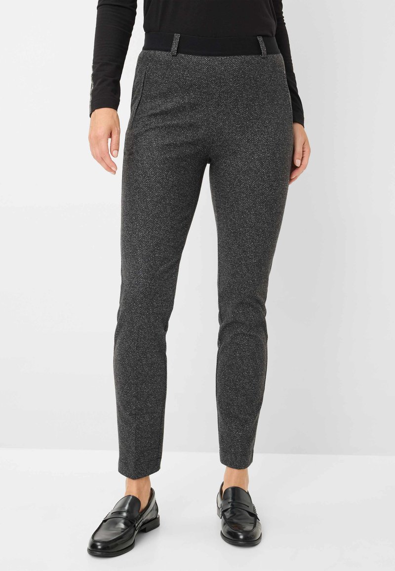 Grijze textuurbroek met een slim fit, voorzien van een zwarte tailleband en een subtiel patroon, gecombineerd met zwarte loafers.