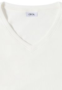 Weißes V-Ausschnitt-T-Shirt aus weichem Stoff, mit genähtem Ausschnitt und einem Etikett mit der Aufschrift "CECIL" in der Mitte des Kragens.