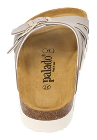 Sandalo slip-on beige chiaro con suola in sughero, soletta testurizzata e fibbia regolabile. Suola bianca e nome del marchio visibile sulla pianta.