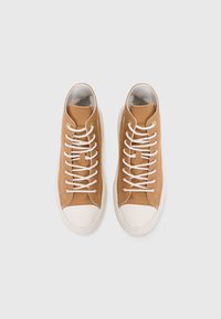 Hoogwaardige sneakers in tan canvas met witte veters, afgeronde neus en crèmekleurige rubberen zool. Goudkleurige ogen en gestructureerde bovenkantdetails.