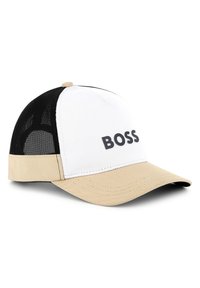 Witte en beige baseballcap met zwarte gaas zijkanten, met een opvallend zwart "BOSS" logo aan de voorkant en een gebogen klep.