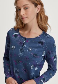 Marineblaues Langarmoberteil mit weltraumthemen Prints in Pink und Weiß, mit einem Henley-Ausschnitt und drei Knöpfen an der Vorderseite.