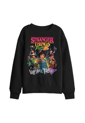 Black sweatshirt featuring colorful Stranger Things: Tales from '85 characters with weapons and text "We Are The H.i.c" on front.