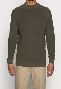 Olivgrüner gestrickter Pullover mit rundem Ausschnitt, geripptem Muster und anliegenden Bündchen. Verfügt über horizontale Streifen an den Ärmeln.