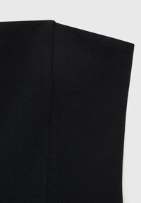 Crni materijal s glatkom teksturom, s minimalističkim dizajnom i čistim linijama. Naglasak je na čvrstoj boji i presavijenom rubu.